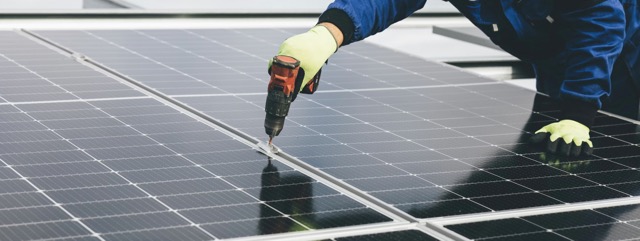 Technicien installant des panneaux solaires photovoltaïques